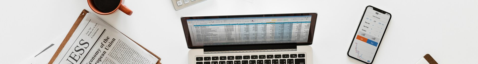 Arbeitsplatz eines Onlinehändlers mit Laptop, Taschenrechner und Unterlagen