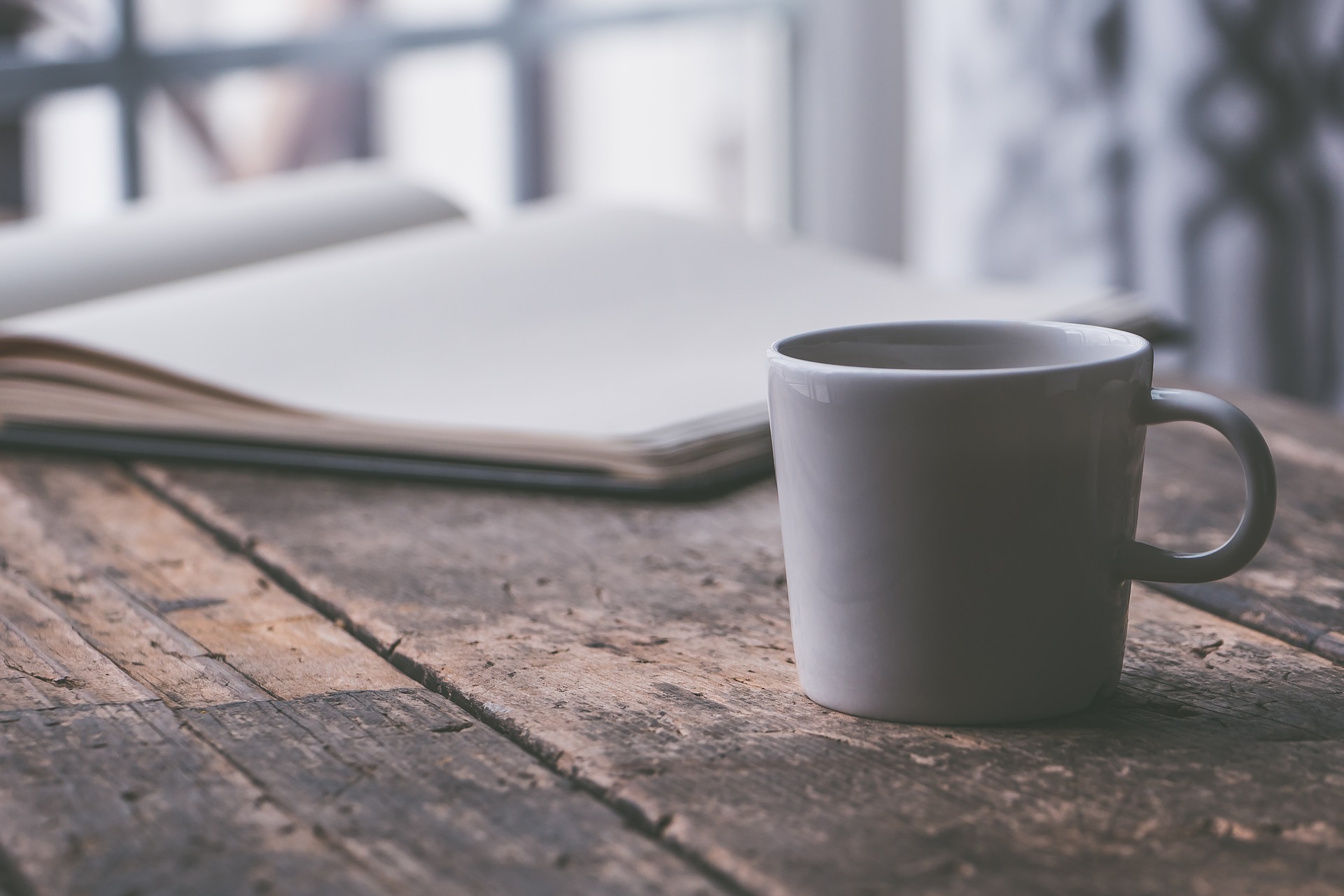 Kaffeetasse mit Notizbuch auf dem Schreibtisch